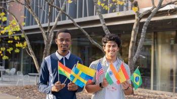 两名学生，Satvik Chethan和Jim Appiah，举着几面不同国家的小国旗.